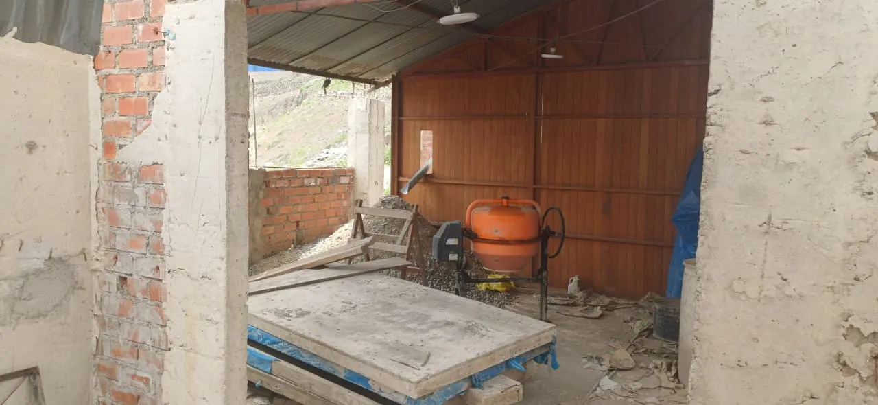 Avance de la construcción de la capilla, con paredes de ladrillo, mezcladora de cemento y materiales de obra