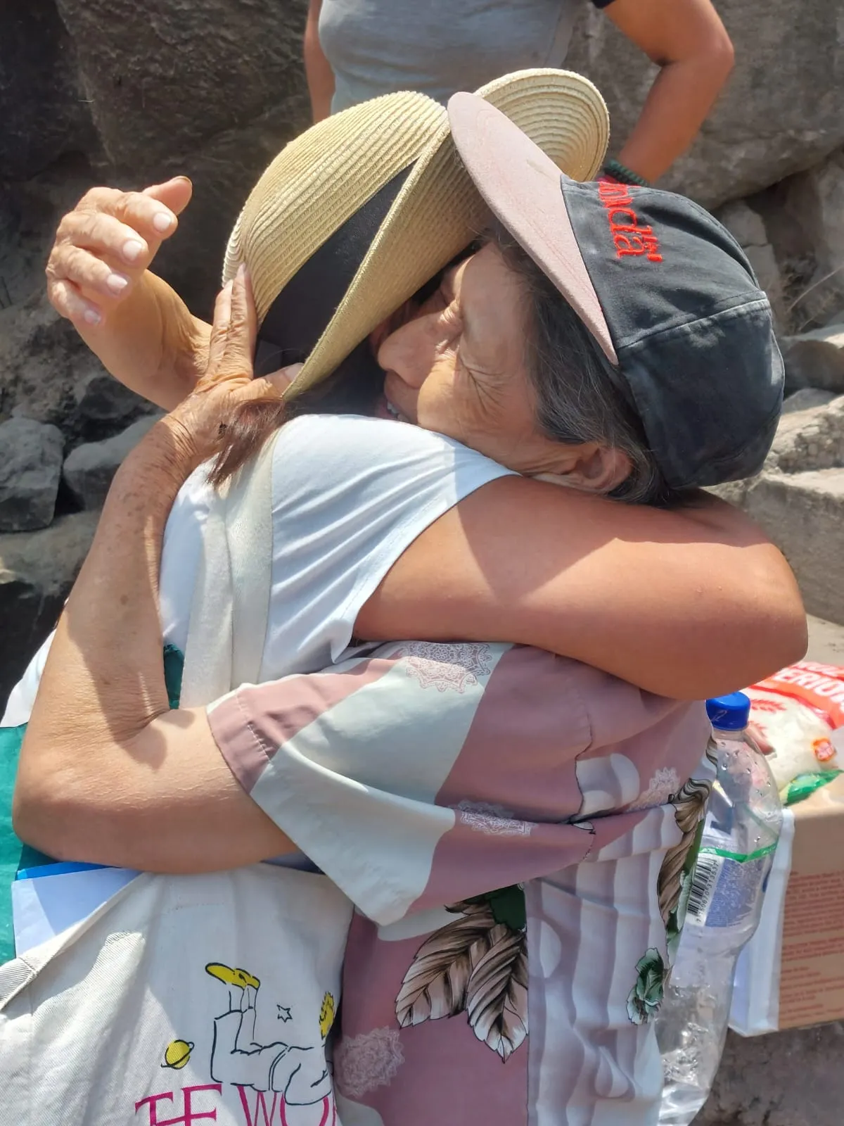 Abrazo entre una voluntaria y la abuelita Fanny Flores durante una visita domiciliaria